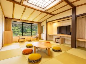 a living room with a table and a tv at Hotel Koyokan in Hanamaki