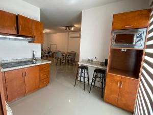 a kitchen with wooden cabinets and a counter top at Habitación 1, en Casa Gabriela in La Paz