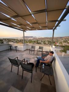 a man sitting on a chair on a roof at Habitación 1, en Casa Gabriela in La Paz