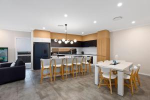 a kitchen and dining room with a table and chairs at Sandy Feet Retreat in The Entrance +3 photos