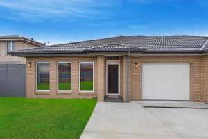 a brick house with a white garage at Sandy Feet Retreat in The Entrance