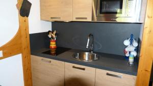 małą kuchnię ze zlewem i kuchenką mikrofalową w obiekcie Résidence Tournavelles - Appartement 2 pièces 5 personnes avec vue sur les pistes, skis aux pieds et des commerces, proche de l'ESF et de la garderie dan MAE-2071 w mieście Arc 1800