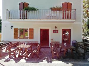 ein Restaurant mit Holztischen und einem Balkon in der Unterkunft Locanda Castil in Arco