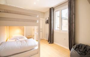ein Schlafzimmer mit Etagenbett und Fenster in der Unterkunft Malebranche - Maison en hypercentre avec cour in Amboise