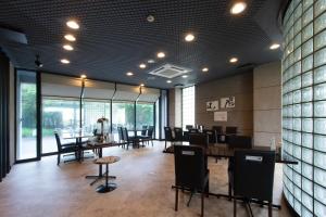 a dining room with tables and chairs and windows at Hotel Arashiyama in Kyoto