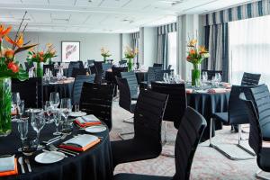 a conference room with tables and chairs and flowers at Leicester Marriott Hotel in Leicester