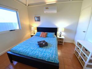 Un dormitorio con una cama con edredón azul y una ventana. en Osprey Holiday Village Unit 112, en Exmouth 10 fotos más