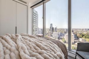 a bed in a room with large windows at West Side Explore Downtown Melb in Chic Condo in Melbourne +26 photos