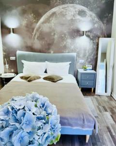 a bedroom with a bed with blue flowers on it at Moon and Sun Apartments in Sibiu