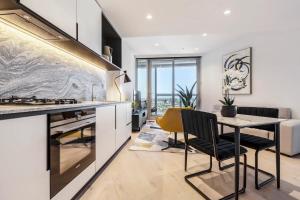 a kitchen with a table and a yellow chair at West Side Explore Downtown Melb in Chic Condo in Melbourne