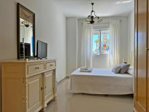 une chambre avec un lit et une commode avec une télévision dans l'établissement Apartamento Playa Ballena - Ole Solutions, à Costa Ballena