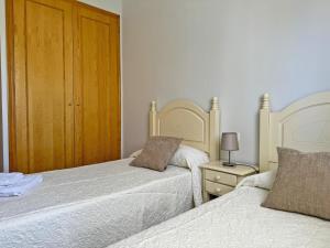 - une chambre avec 2 lits et une table de nuit avec une lampe dans l'établissement Apartamento Playa Ballena - Ole Solutions, à Costa Ballena 15 autres photos