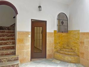 a hallway with a wooden door and a staircase at Apartamento J Burgos - Ole Solutions in El Puerto de Santa María