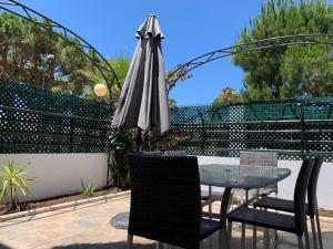 stół i krzesła z parasolem na patio w obiekcie Apartamento Galeón - Ole Solutions w mieście El Puerto de Santa María