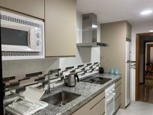 kuchnia ze zlewem i mikrofalówką w obiekcie Apartamento Galeón - Ole Solutions w mieście El Puerto de Santa María