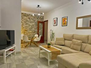salon z kanapą i telewizorem w obiekcie Apartamento Armas - Ole Solutions w mieście Jerez de la Frontera