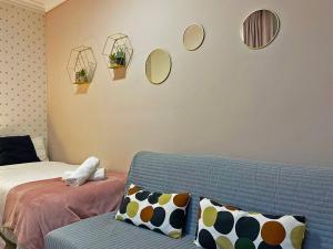 salon z kanapą i lustrami na ścianie w obiekcie Apartamento Armas - Ole Solutions w mieście Jerez de la Frontera
