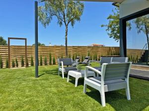 a row of chairs sitting on the grass at Casa Las Mironas I - Ole Solutions in El Puerto de Santa María +18 photos