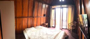 a bedroom with a bed in a room with wooden walls at Pondok Kebun Gunung in Bedugul