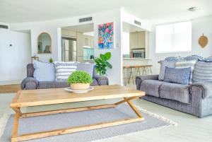 a living room with two couches and a coffee table at Hamptons Style Penthouse at Kings Beach in Caloundra