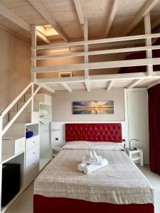 a bedroom with a large bed with a red headboard at Blue Inn Residence e B&B in Lido delle Nazioni +19 photos