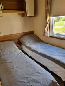 two beds in a small room with a window at Villa Gullebo in Sandåkra