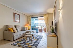 a living room with a couch and a table at Top Floor Ocean View Apt By Dream Homes Tenerife in Puerto de Santiago