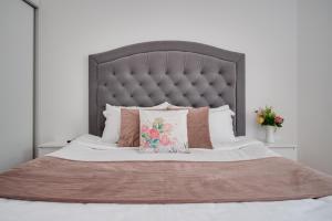 a large bed with a gray headboard and pillows at Queen's view 14-Pools-Near Botanic garden in Balchik +14 photos