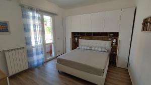 een slaapkamer met een groot bed en een groot raam bij Conca del Sole in Rapallo
