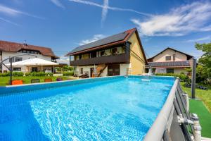 a swimming pool in front of a house at Merry's House w/ Pool, Sauna & Jacuzzi - Happy Rentals in Griblje +35 photos