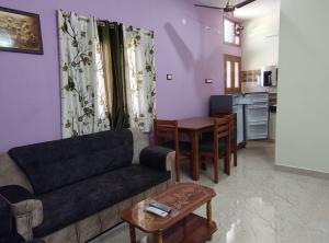 una sala de estar con un sofá y una mesa en LP Homestay, en Yelagiri