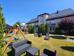 a yard with a playground with a swing at Willa Ibis in Karwia