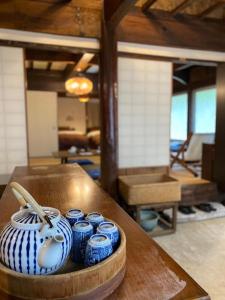 大岛島家 - 古民家一棟貸し-的桌子上放着一组蓝色罐子