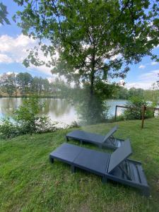a picnic table and bench in front of a lake at Les Pichies La tanière du pêcheur in Saint-Léger-sur-Vouzance +6 photos