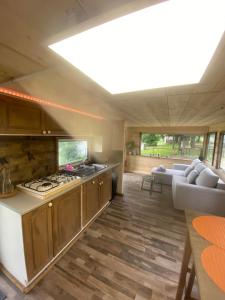a kitchen and living room with a stove and a couch at Les Pichies La tanière du pêcheur in Saint-Léger-sur-Vouzance