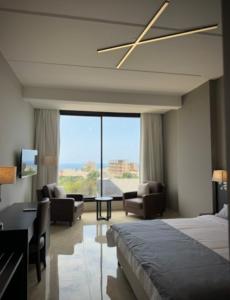 a bedroom with a bed and a living room at 365 UrbanLiving in Jbeil