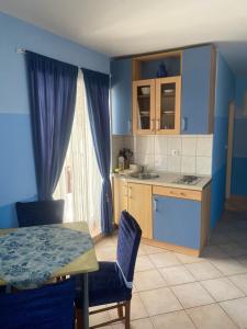 a kitchen with blue walls and a table and chairs at Apartments Villa Dalmatina in Vodice