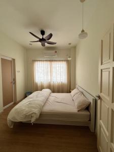 Un dormitorio con una cama con ventilador de techo. en Blossom Hill homestay, en Kuantan