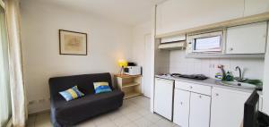 a kitchen with a couch and a sink in a room at Port Frejus, 100 m des plages, le CESAREE, T2 30m2 in Fréjus