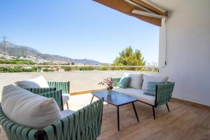 a patio with chairs and a table with a view at Villa RUBI in Nerja
