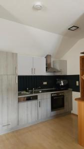 a kitchen with white cabinets and a sink and a stove at Haus Ela in Sächsenheim