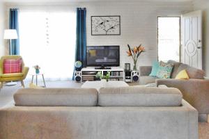 a living room with a couch and a tv at Allara 1 in Merimbula