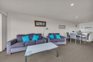 a living room with a couch and a table at Baywatch 5 in Merimbula