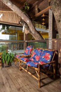 a chair sitting on a porch with a tree at Pousada Dona Elena in Penha