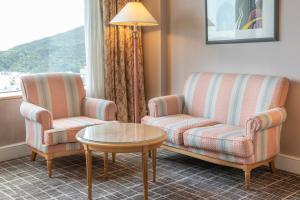 a living room with two chairs and a table at Lotte Hotel Busan in Busan