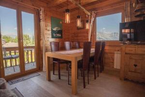 a dining room with a table and chairs in a cabin at Chalet avec vue in Nendaz