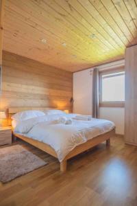 a bedroom with a large bed with a wooden ceiling at Chalet avec vue in Nendaz