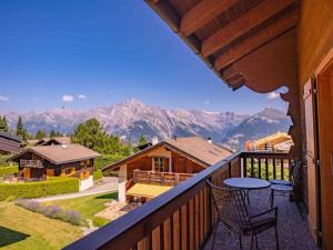 a balcony with a table and chairs and mountains at Chalet avec vue in Nendaz
