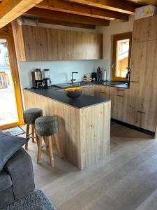 a kitchen with a sink and a counter with stools at Chalet avec vue in Nendaz