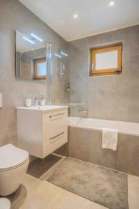 a bathroom with a toilet and a sink and a tub at Chalet avec vue in Nendaz +15 photos